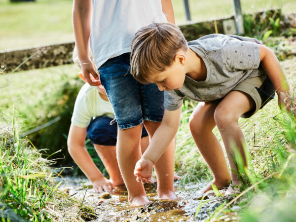 Kinder spielen im Bach