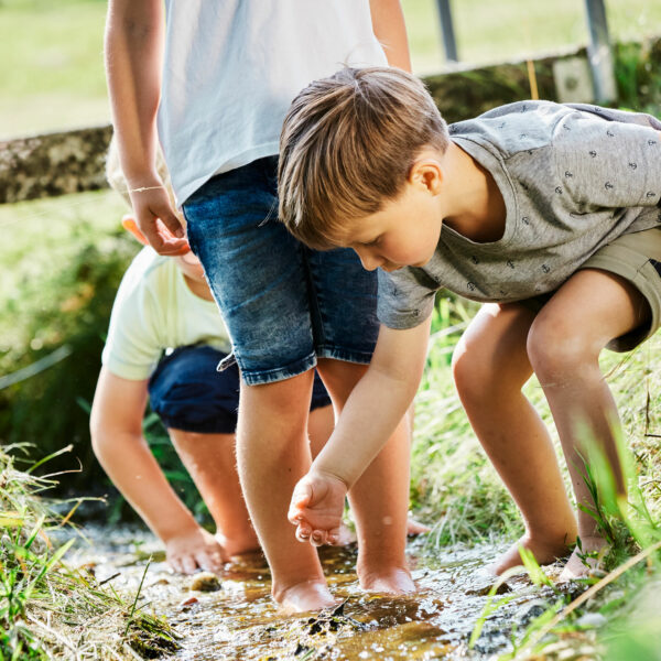 Kinder spielen im Bach