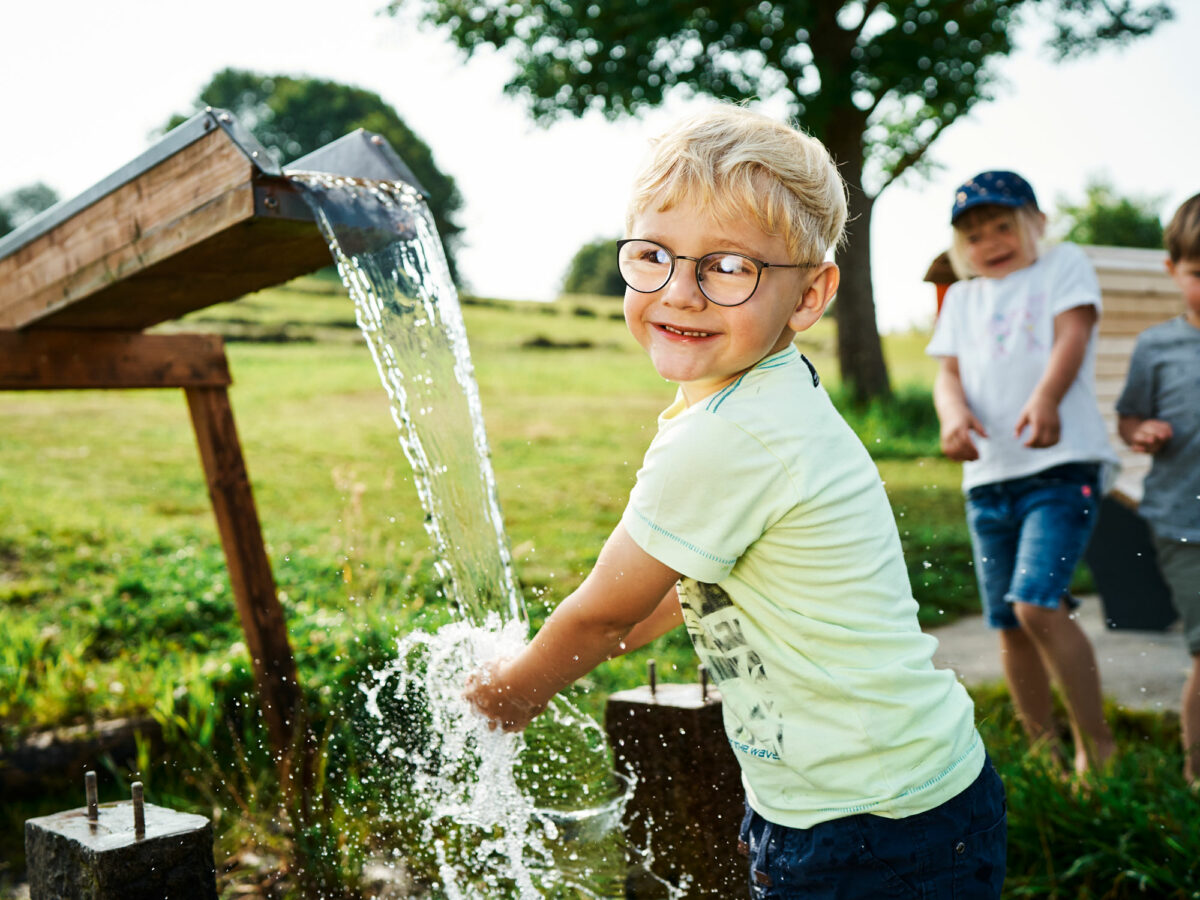 Kinder spielen mit Wasser