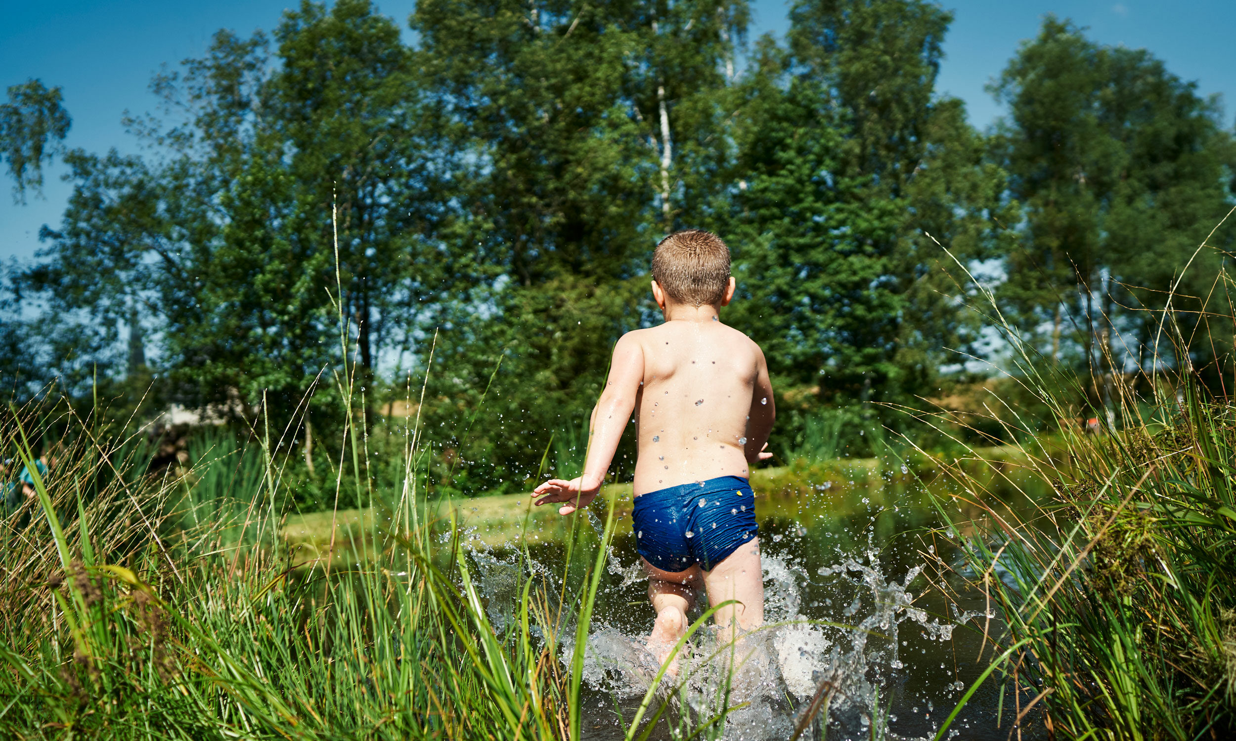 Junge läuft ins Wasser.