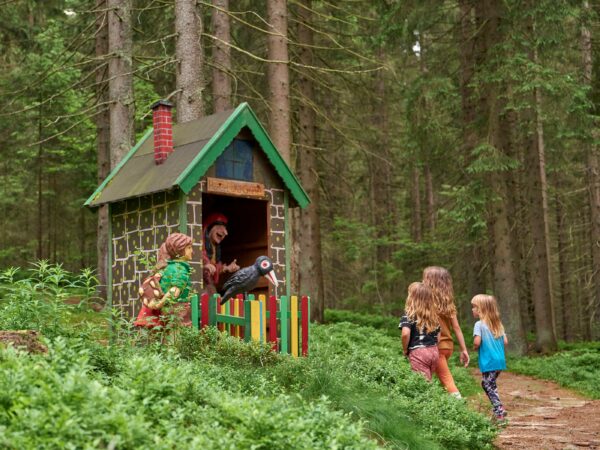 Kinder laufen zum Märchenhaus im Wald